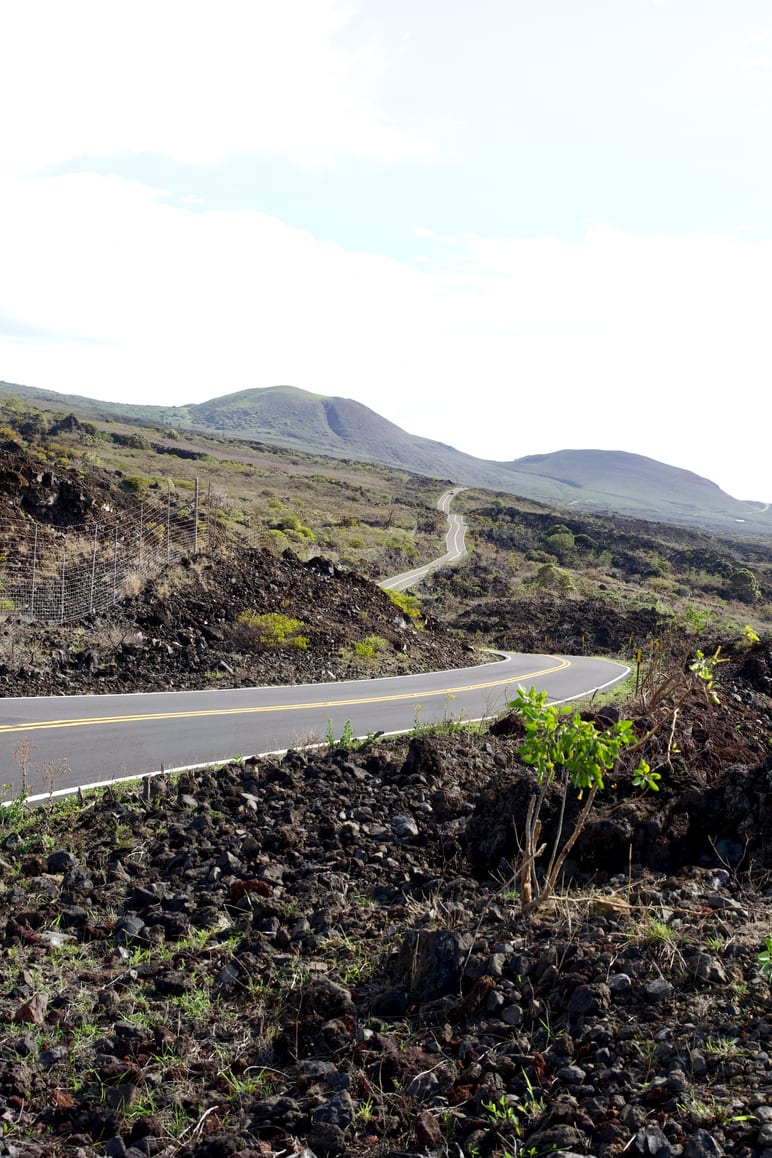 A winding paved road through a rocky volcanic landscape