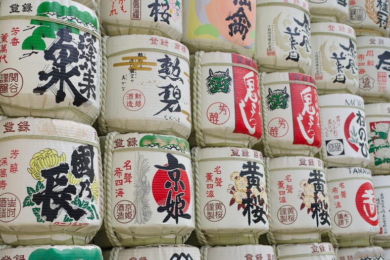 Rows of decorated wooden barrels wrapped in straw are stacked together