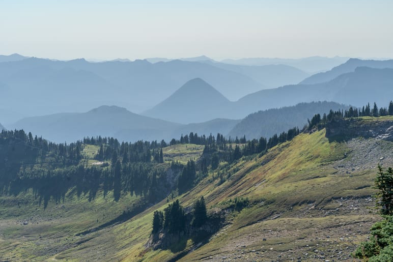Layered mountain ridges fading into haze under a pale sky